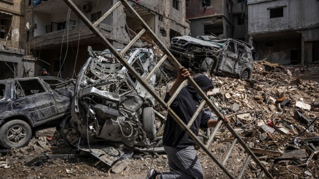 A resident carries a ladder through a destroyed neighborhood the morning after an Israeli airstrike in Beirut, on Monday, April 6, 2026. Residents in Lebanon were reeling on Monday from an intense wave of Israeli airstrikes in recent days, including in an area near Beirut, the capital, that had once been considered safe from attacks. (David Guttenfelder/The New York Times)