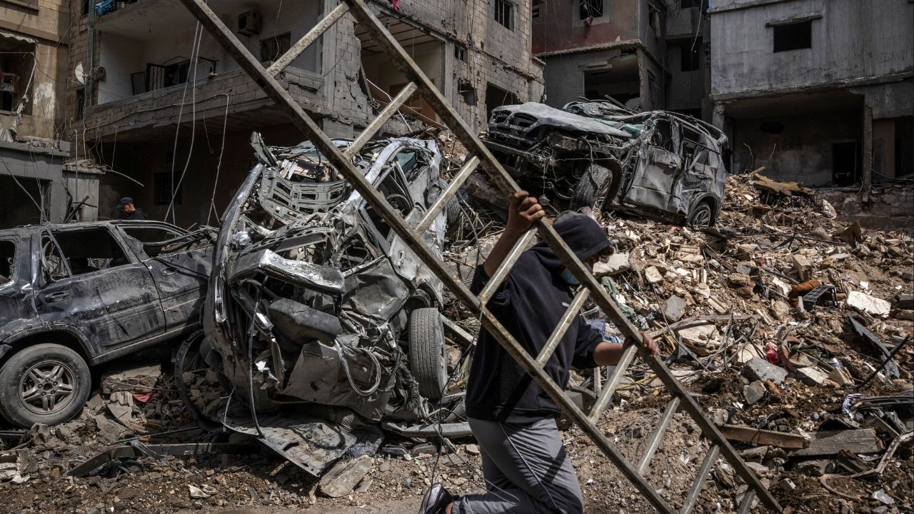 A resident carries a ladder through a destroyed neighborhood the morning after an Israeli airstrike in Beirut, on Monday, April 6, 2026. Residents in Lebanon were reeling on Monday from an intense wave of Israeli airstrikes in recent days, including in an area near Beirut, the capital, that had once been considered safe from attacks. (David Guttenfelder/The New York Times)