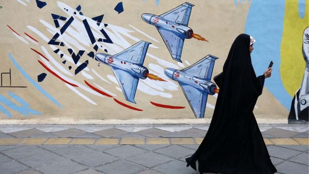 A woman walks next to an anti-Israeli mural on a street, amid a ceasefire between U.S. and Iran, in Tehran, Iran, April 20, 2026. Majid Asgaripour/WANA via REUTERS