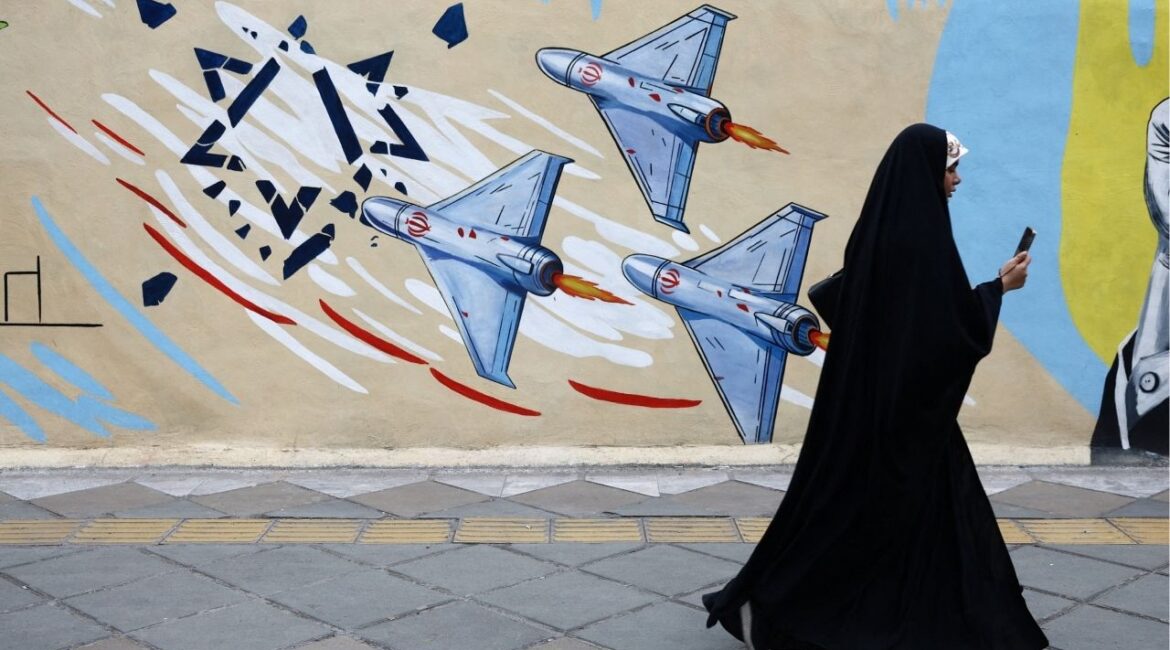 A woman walks next to an anti-Israeli mural on a street, amid a ceasefire between U.S. and Iran, in Tehran, Iran, April 20, 2026. Majid Asgaripour/WANA via REUTERS