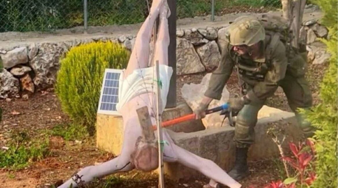 An Israeli soldier damages the head of a statue of Jesus, in Debel, Lebanon, in this still image obtained from social media released on April 19, 2026. Social Media/via REUTERS