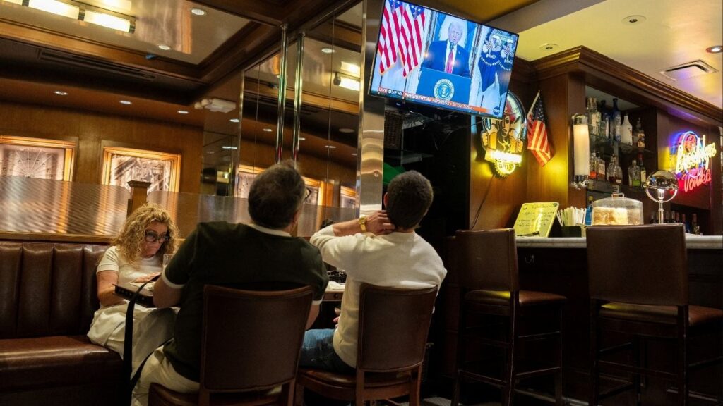 Customers watch U.S. President Donald Trump address the nation on the Iran crisis from the White House in Washington, D.C., on screen at Brooklyn Diner in Times Square, New York, U.S., April 1, 2026. (Reuters/David Dee Delgado)