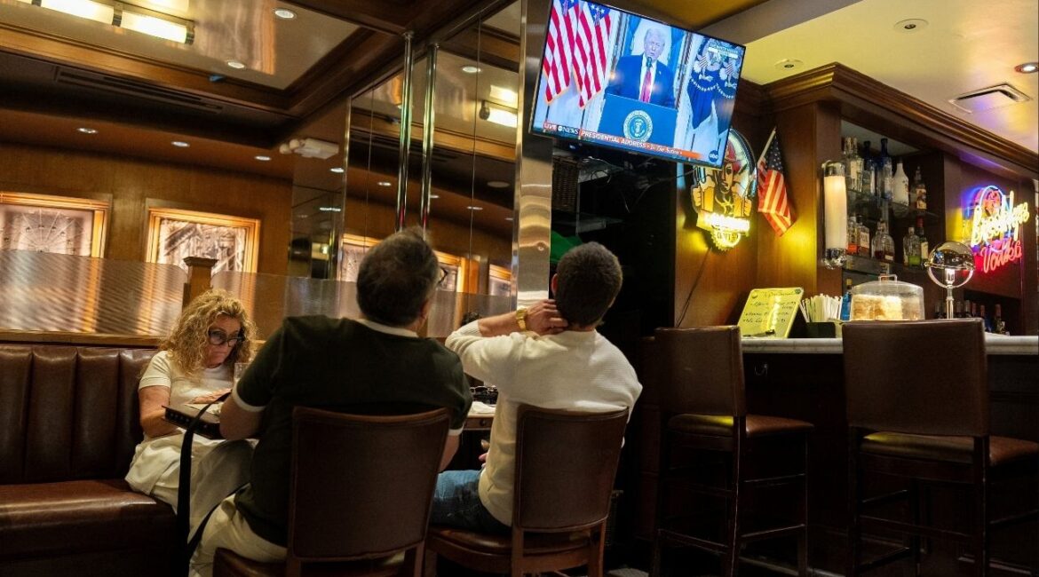 Customers watch U.S. President Donald Trump address the nation on the Iran crisis from the White House in Washington, D.C., on screen at Brooklyn Diner in Times Square, New York, U.S., April 1, 2026. (Reuters/David Dee Delgado)