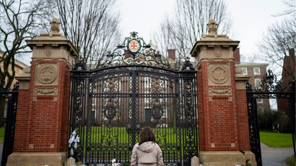 Hannah Chen, a junior at Brown University, leaves flowers at the Van Wickle Gates at the Brown University campus in Providence, R.I., on Dec. 15, 2025. The man who killed two Brown University students and an MIT professor last December plotted the crimes over the course of three years, federal law enforcement officials said Wednesday, April 29, 2026. (Christopher Capozziello/The New York Times)