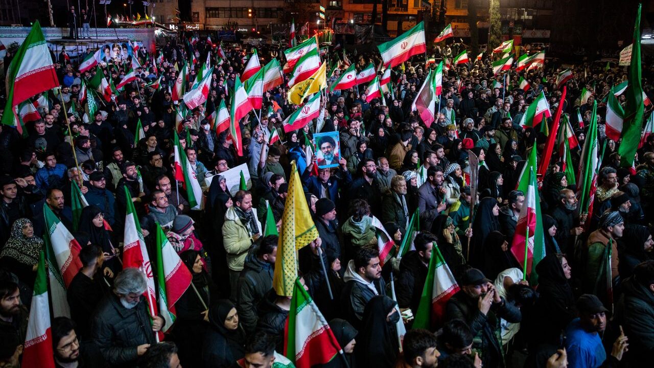 Image of Iranians celebrating the two-week cease-fire. Many are waving Iranian flags.