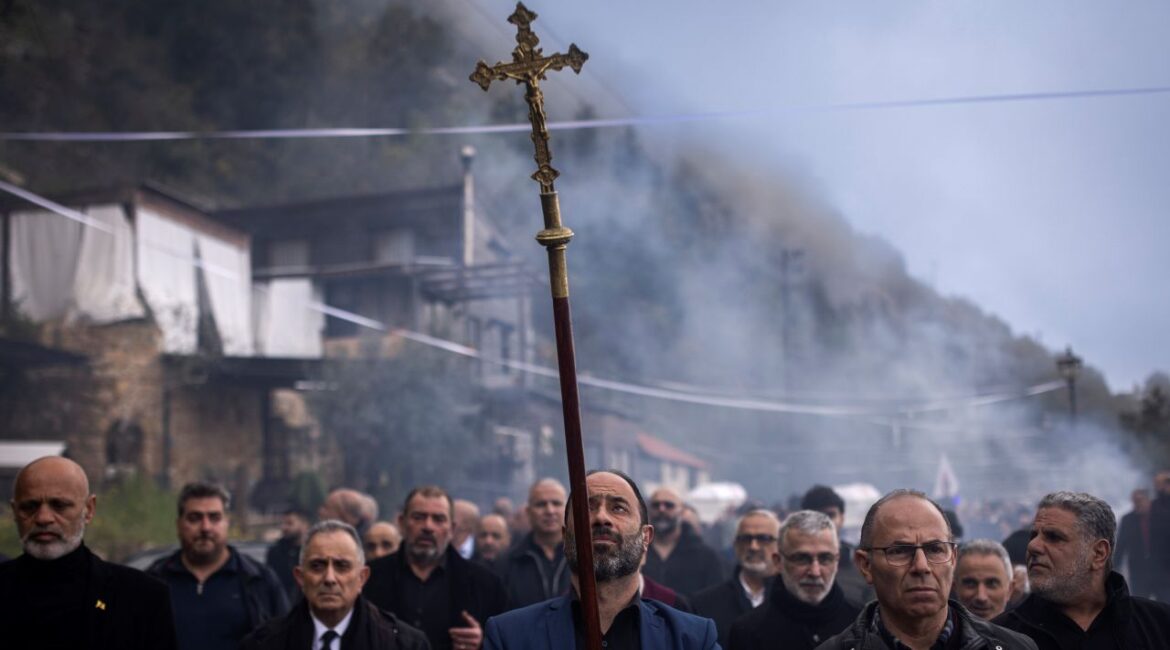 Image of Christian men in Lebanon marching with a cross in a funeral for a slain military member