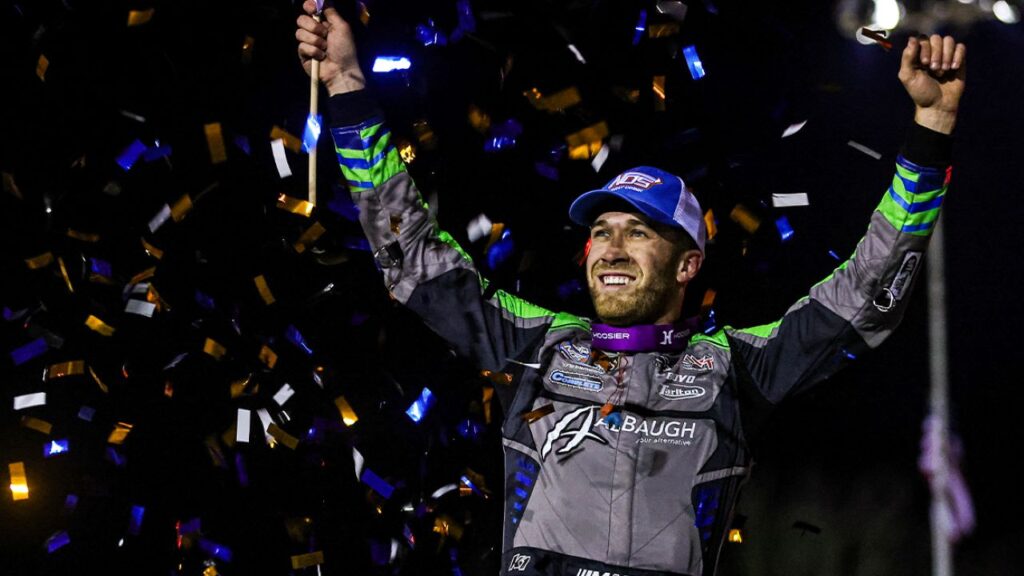 Image of sprint car driver Carson Macedo celebrating a victory. There's confetti falling through the night air.
