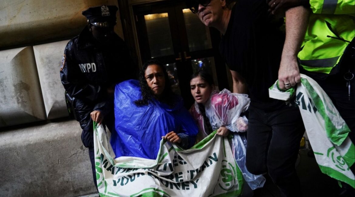 NYPD officers detain activists protesting outside the Federal Reserve Bank of New York during a demonstration calling for the U.S. government to take action on climate change and reject the use of fossil fuels during Climate Week in the Financial District of New York City, New York, U.S., September 18, 2023. (Reuters/Bing Guan)