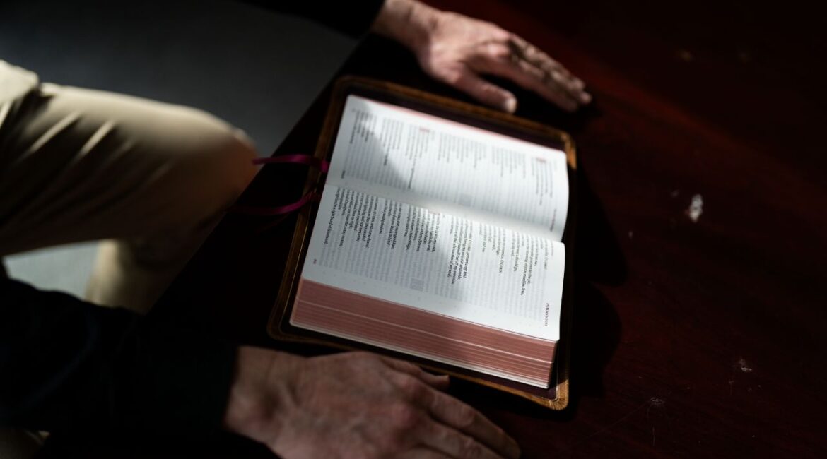 Image of an open bible and two hands