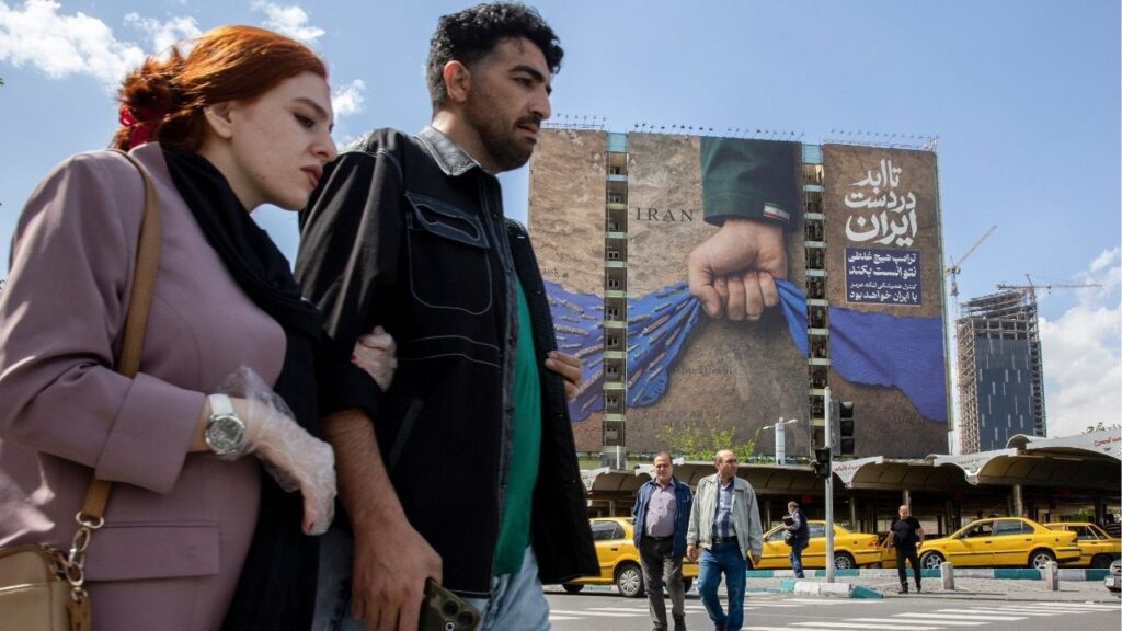 People pass near a billboard depicting a hand representing Iran holding the Strait of Hormuz, in Tehran, Iran, on Tuesday, April 21, 2026. Vice President JD Vance’s trip to Pakistan for a second round of negotiations with Iran has been put on hold after Tehran failed to respond to American positions, a U.S. official with direct knowledge of the situation said on Tuesday. (Arash Khamooshi/The New York Times)