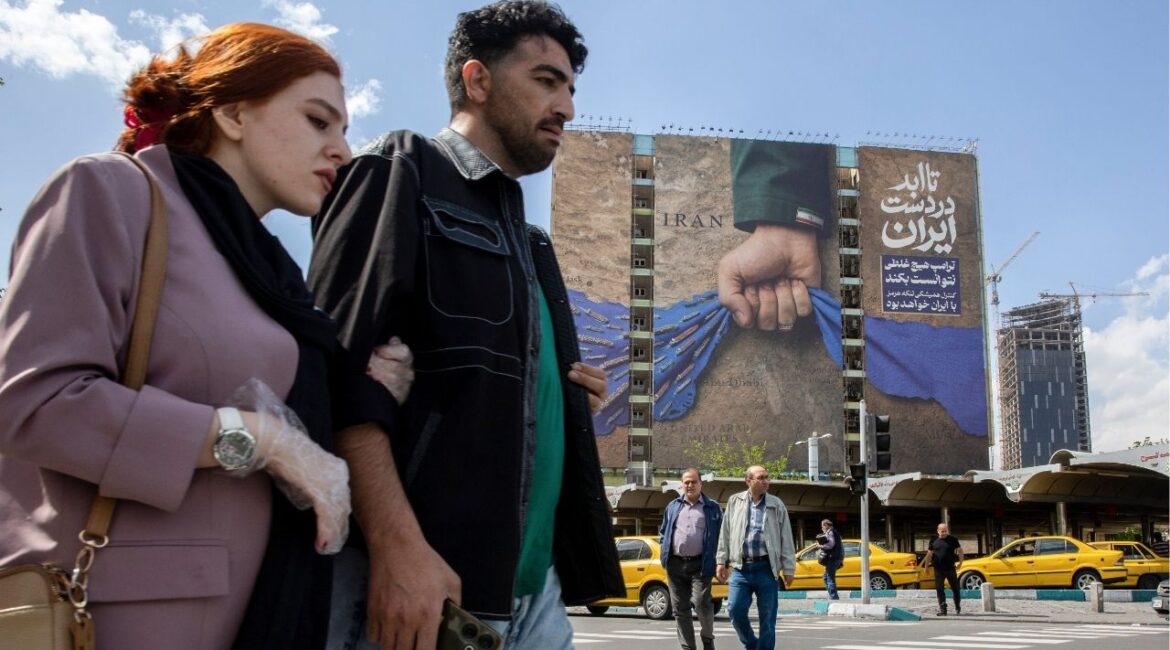 People pass near a billboard depicting a hand representing Iran holding the Strait of Hormuz, in Tehran, Iran, on Tuesday, April 21, 2026. Vice President JD Vance’s trip to Pakistan for a second round of negotiations with Iran has been put on hold after Tehran failed to respond to American positions, a U.S. official with direct knowledge of the situation said on Tuesday. (Arash Khamooshi/The New York Times)