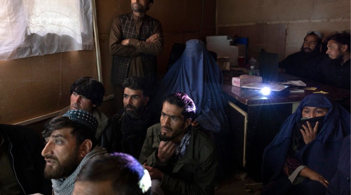 Rokhshana Shah Mohammadi, center, fully covered, and Abida Stanikzai, far right, gather with others at a morgue to look through hundreds of photos of bodies that have been recovered, in Kabul, March 22, 2026. With Pakistan and Afghanistan in open conflict, on March 16 at least two Pakistani airstrikes hit a drug rehabilitation facility in the Afghan capital in the deadliest single attack on civilians in Afghanistan since the Taliban regained power in 2021. (Kiana Hayeri/The New York Times)