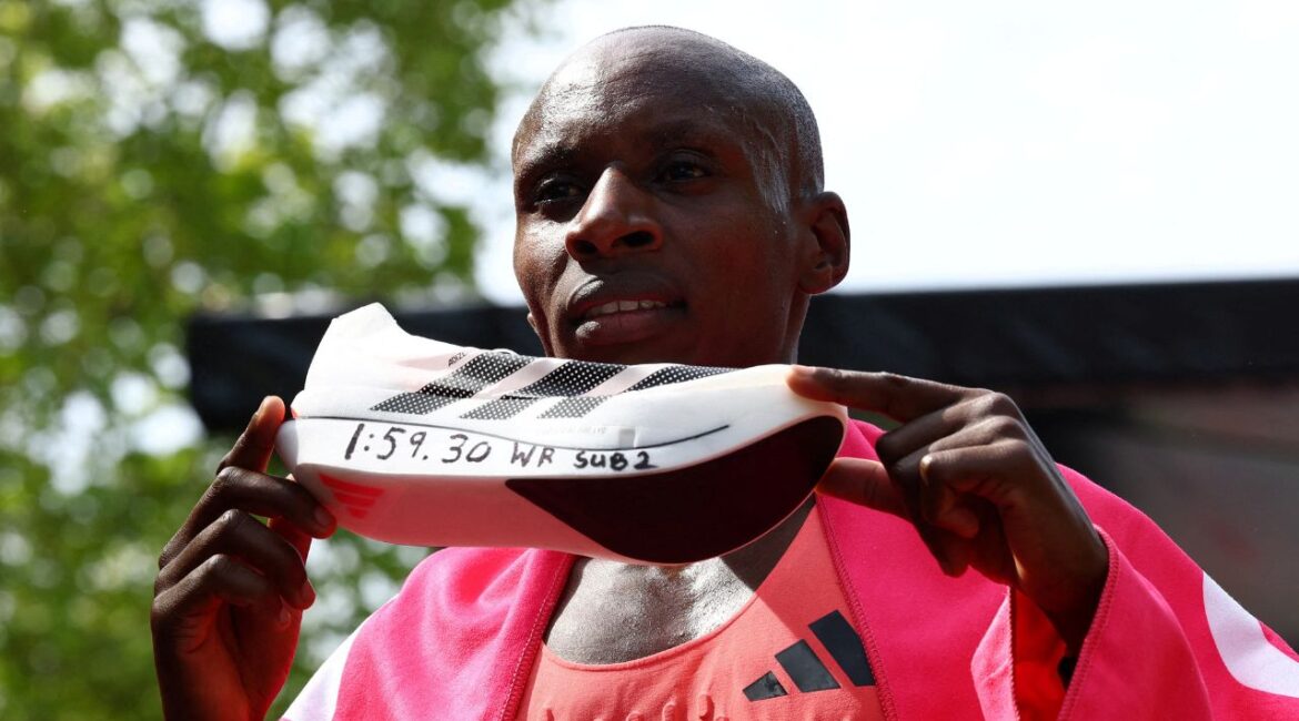 April 26, 2026 Kenya's Sabastian Sawe celebrates with an Adidas Adizero Adios Pro Evo 3 shoe after winning the men's elite race and setting a new world record with a time of 01:59:30 (REUTERS/Matthew Childs)