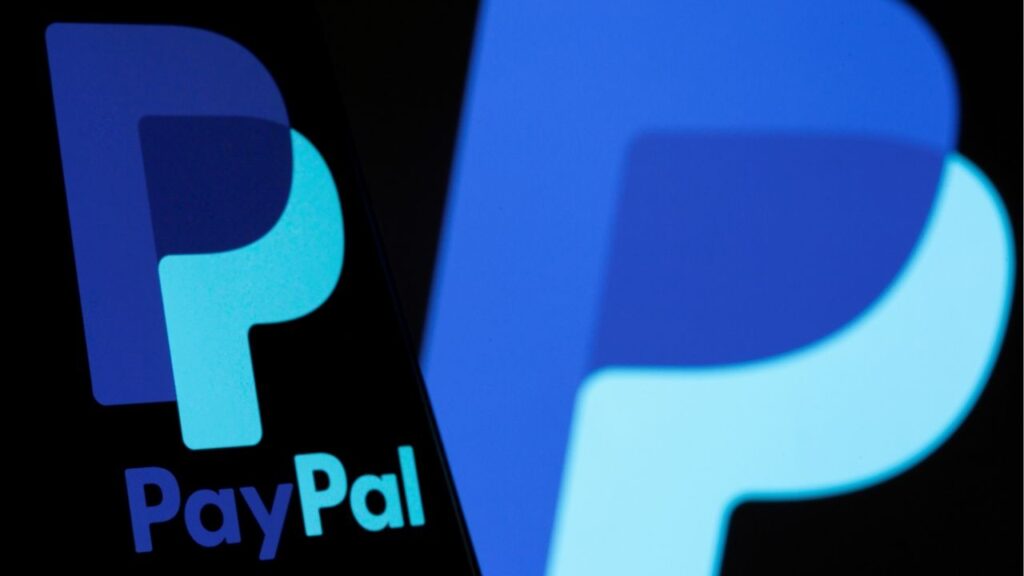 The PayPal logo is seen on a smartphone in front of the same logo displayed in this illustration taken September 8, 2021. REUTERS/Dado Ruvic/Illustration