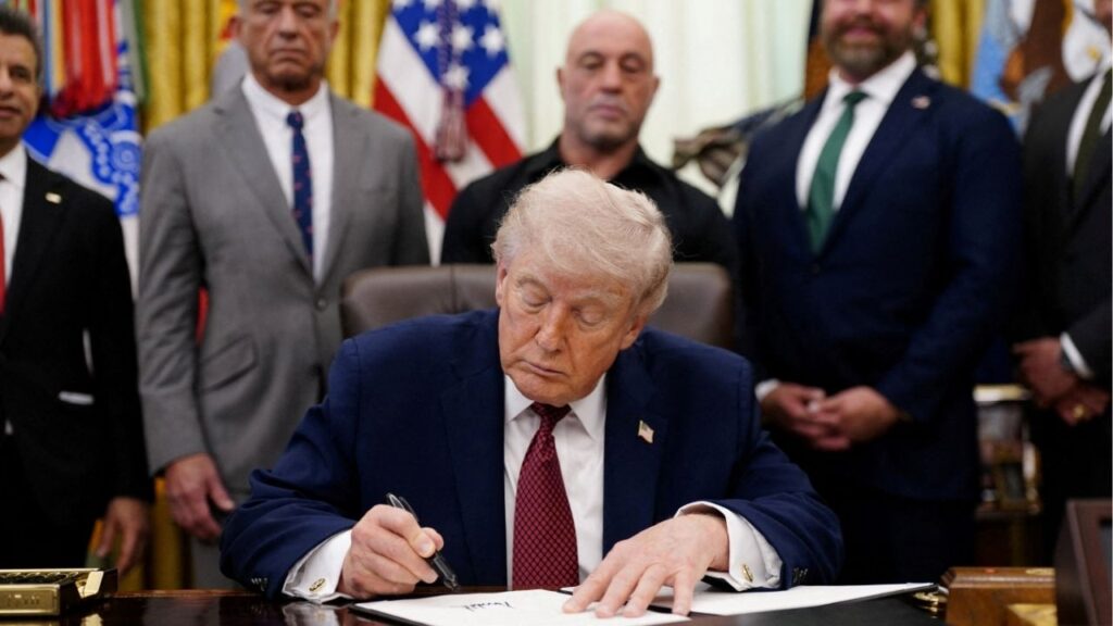 U.S. President Donald Trump signs an executive order encouraging more research into ibogaine, next to U.S. Health and Human Services (HHS) Secretary Robert F. Kennedy Jr., Joe Rogan, and Americans for Ibogaine CEO W. Bryan Hubbard, in the Oval Office of the White House in Washington, D.C., April 18, 2026. REUTERS/Nathan Howard