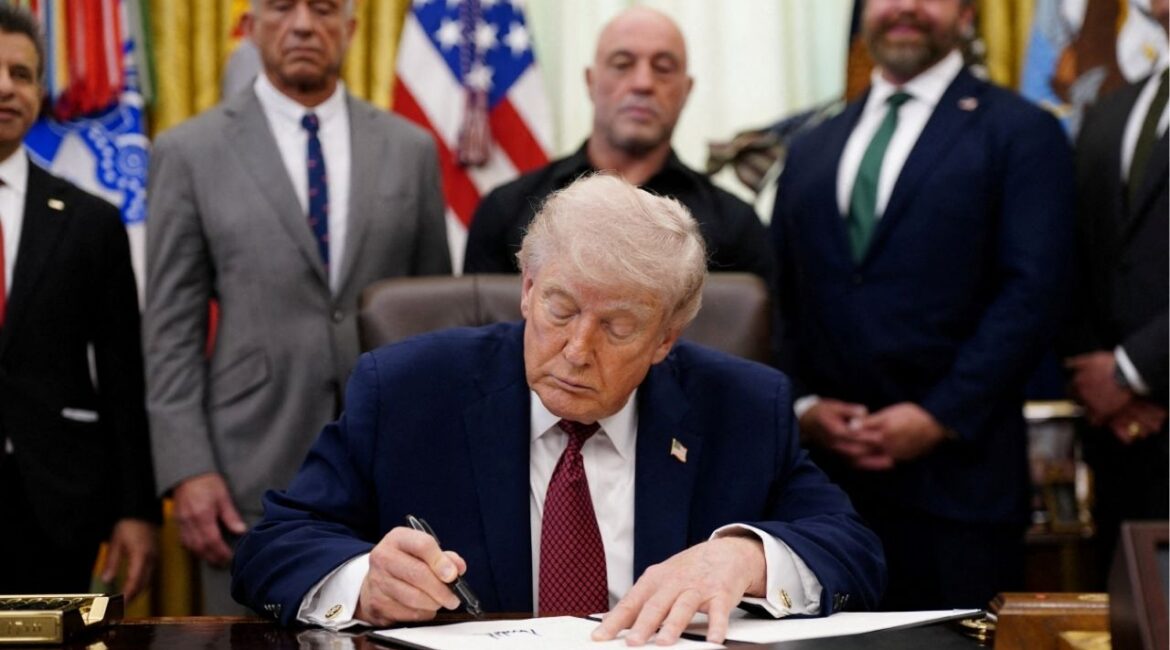 U.S. President Donald Trump signs an executive order encouraging more research into ibogaine, next to U.S. Health and Human Services (HHS) Secretary Robert F. Kennedy Jr., Joe Rogan, and Americans for Ibogaine CEO W. Bryan Hubbard, in the Oval Office of the White House in Washington, D.C., April 18, 2026. REUTERS/Nathan Howard