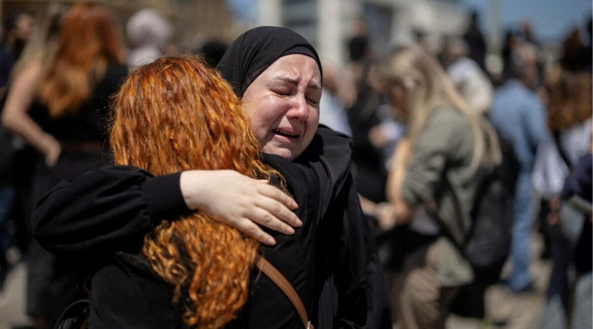 Women react as they hug each other while protesters, including members of the media, attend a vigil to condemn the killing of journalists, a day after journalist Amal Khalil was killed in an Israeli strike, in Martyrs' Square, Beirut, Lebanon April 23, 2026. (Reuters/Marko Djurica)