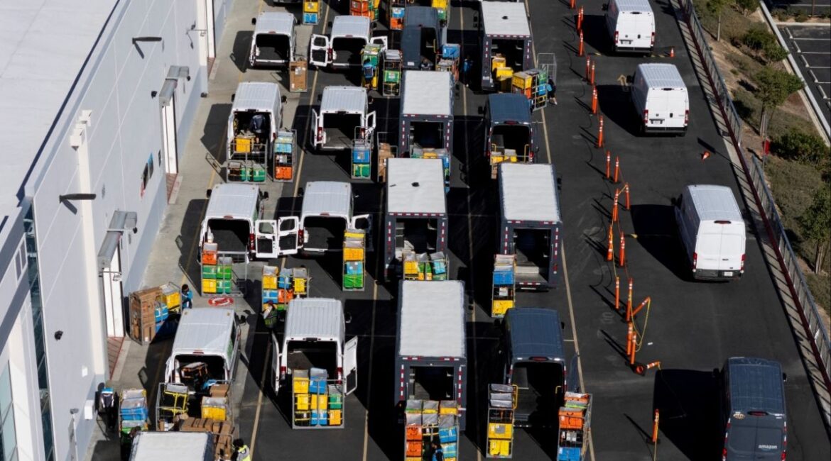 Workers load vans with packages at an Amazon fulfillment center in Valencia, California, December 4, 2025. (Reuters File)