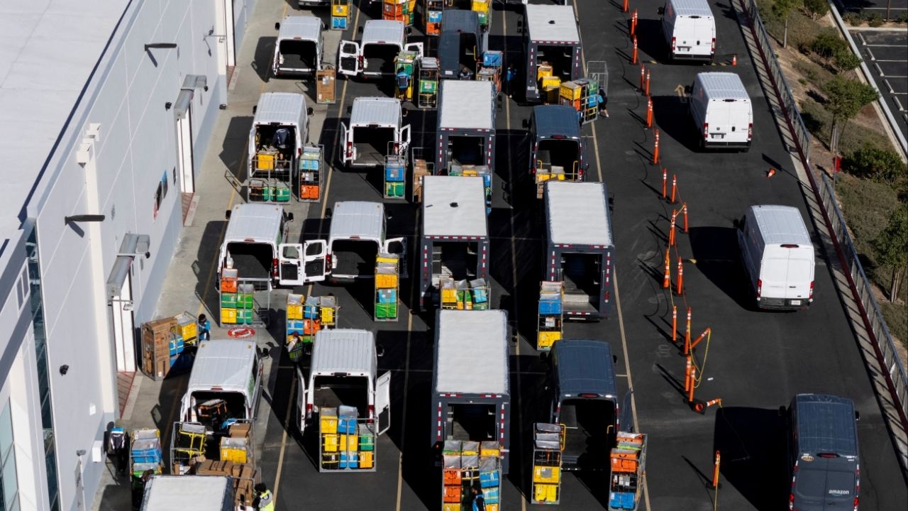 Workers load vans with packages at an Amazon fulfillment center in Valencia, California, December 4, 2025. (Reuters File)