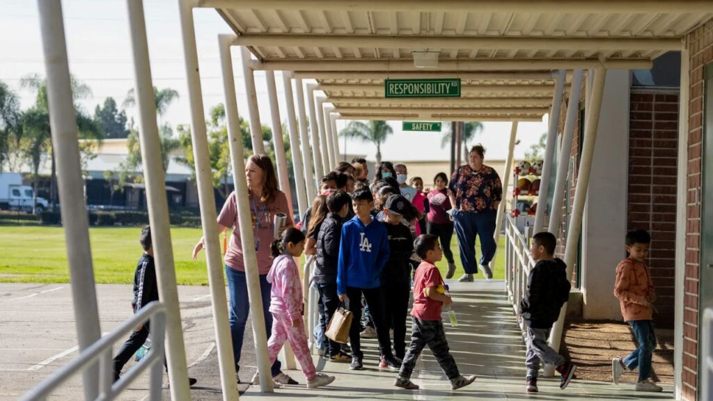 Image of young students walking through the outdoor hallways of Lake Marie Elementary School.