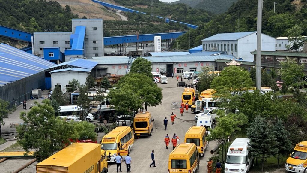 Image of yellow emergency vans and first responders at the scene of a coal plant explosion