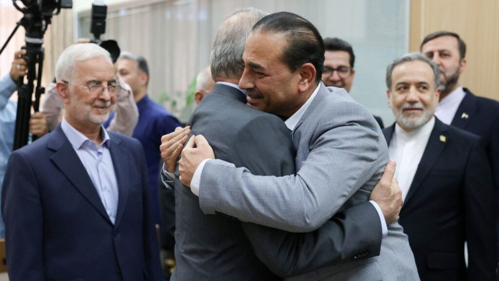 Image of Iranian and Pakistani leaders embracing in a crowd of other dignitaries