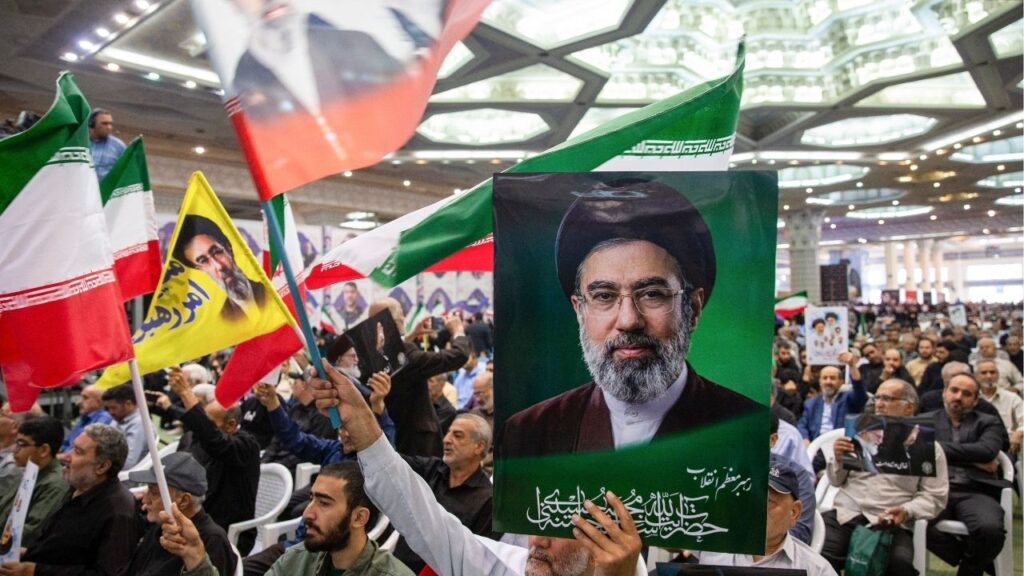 A man holds a photo of Mojtaba Khamenei, the new supreme leader, at a memorial ceremony for the victims of the war with the U.S. and Israel, in Tehran, Iran, on Sunday, May 24, 2026. Iran’s Revolutionary Guards warned on Tuesday that they would issue a “decisive reciprocal response” to any attacks that violated the cease-fire. (Arash Khamooshi/Polaris for The New York Times)