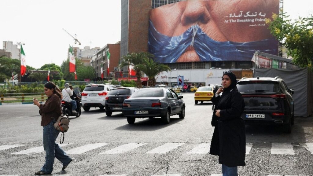 A woman walks past an anti-U.S. billboard depicting U.S. President Donald Trump and the Strait of Hormuz, in Tehran, Iran, May 17, 2026. (Majid Asgaripour/WANA (West Asia News Agency) via Reuters)