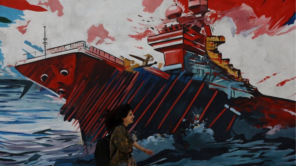 An Iranian woman walks next to a mural on a street in Tehran, Iran, May 6, 2026. Majid Asgaripour/WANA (West Asia News Agency) via REUTERS