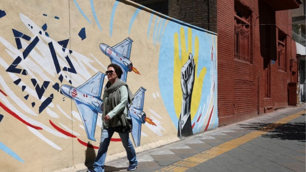 An Iranian woman walks next to an anti-Israeli mural on a street in Tehran, Iran, May 26, 2026. (Majid Asgaripour/WANA (West Asia News Agency) via Reuters)