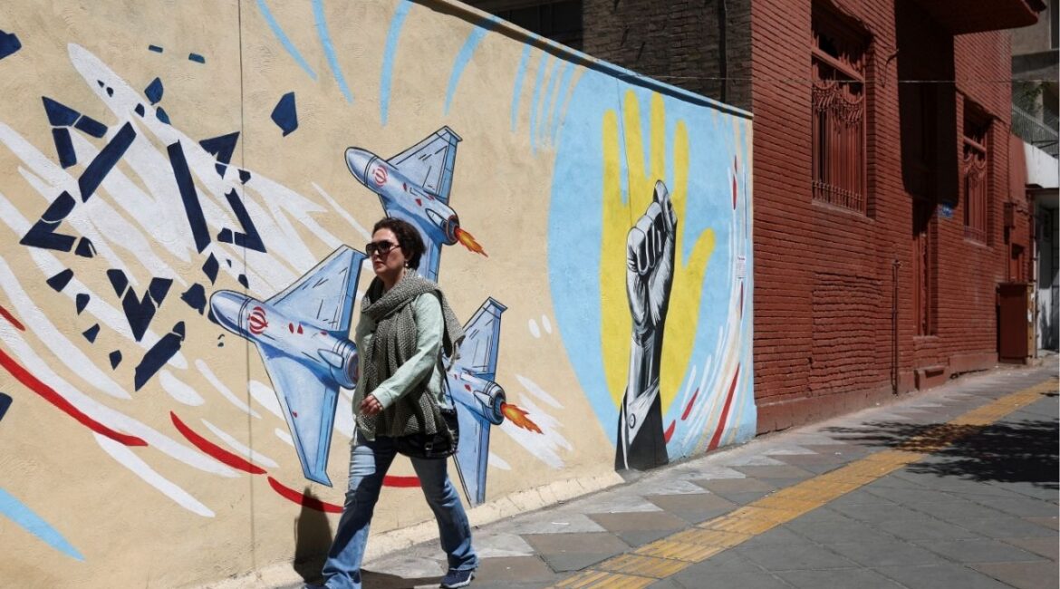 An Iranian woman walks next to an anti-Israeli mural on a street in Tehran, Iran, May 26, 2026. (Majid Asgaripour/WANA (West Asia News Agency) via Reuters)