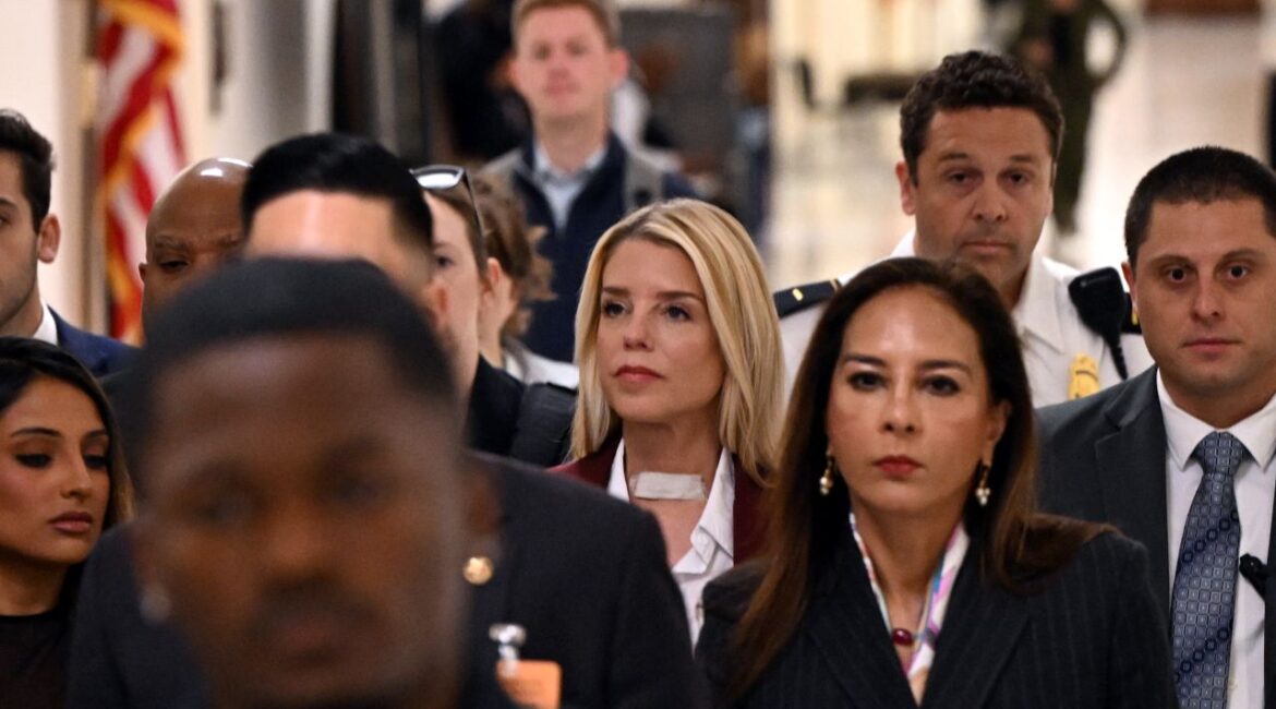 Image of former AG Pam Bondi arriving for a House hearing while surrounded by a crowd of people