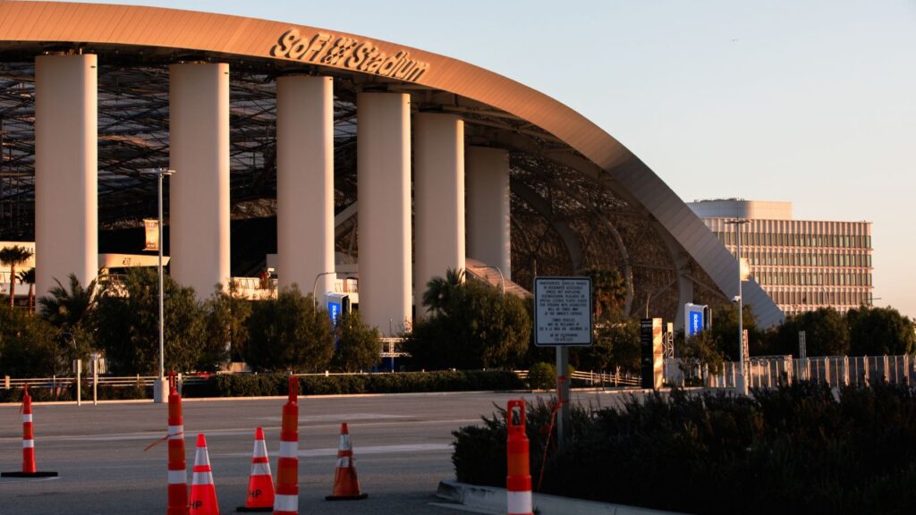 Image of SoFi Stadium and its exterior columns along with an adjacent street and orange traffic cones