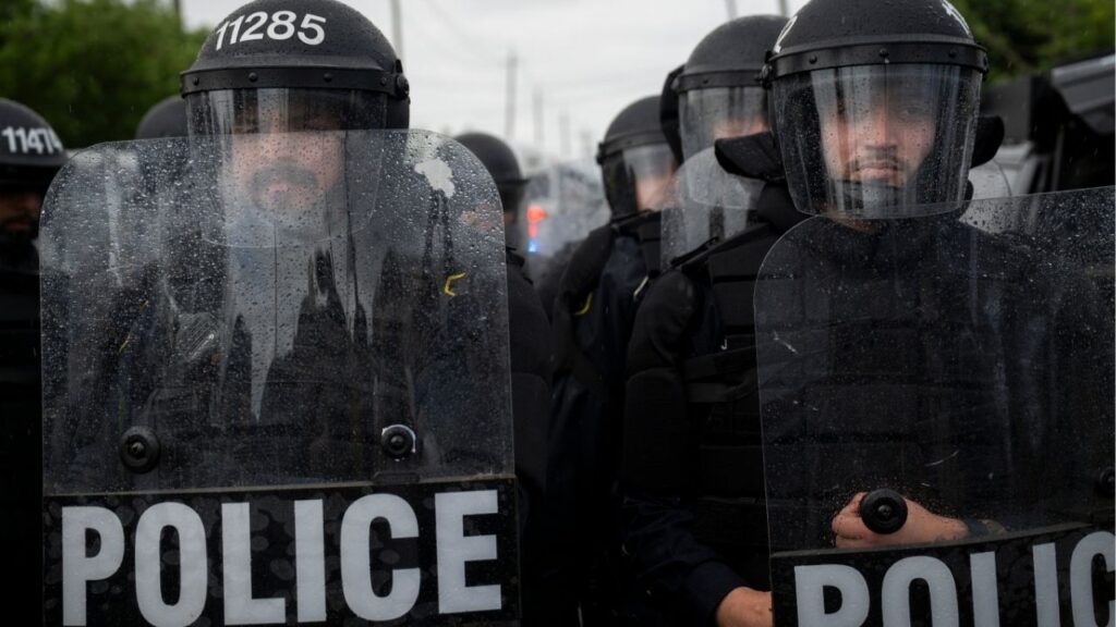 City of Newark police officers in riot gear monitor the anti-ICE demonstrations and counterprotests outside Delaney Hall, a federal detention facility in Newark, N.J. on Saturday, May 30, 2026. Clashes between protesters and armed federal agents here have flared off and on since the Memorial Day weekend; on Friday, federal officials left the area outside the detention center so that the state police could assume control. (Vincent Alban/The New York Times)