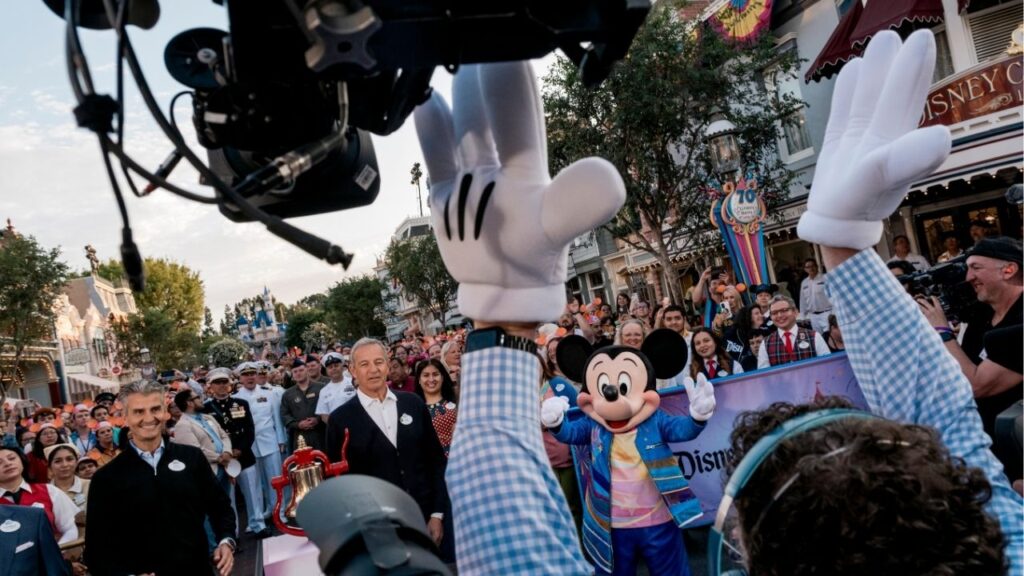 Josh D’Amaro, left, now Disney’s chief executive, and Bob Iger, center, then Disney’s chief executive, at Disneyland’s 70th anniversary commemoration in Anaheim, Calif., July 17, 2025. D’Amaro, who took over Disney in March 2026, publicly faced Wall Street for the first time on Wednesday, reporting quarterly earnings that exceeded analyst expectations. (Mark Abramson/The New York Times)