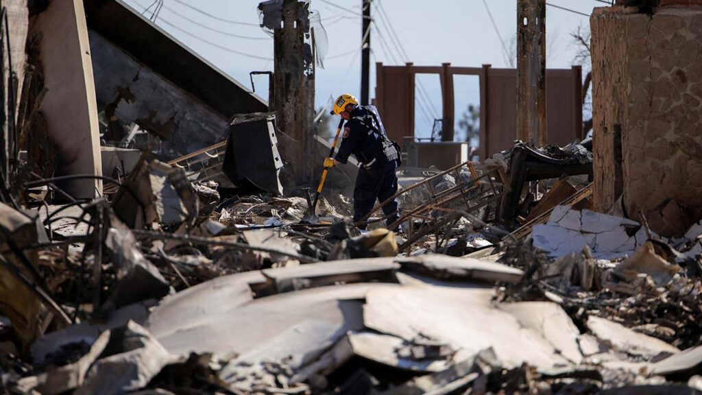 A search and rescue worker investigates the charred remains of a house, as the Eaton Fire continues, in Altadena, Los Angeles County, California, U.S. January 15, 2025. (Reuters/Daniel Cole)