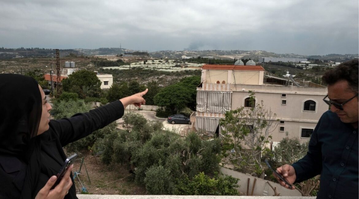 Local residents look out at the smoke billowing on the horizon after an Israeli missile strike near Baysarieh, in southern Lebanon, on Wednesday, May 27, 2026. Residents of the town of Baysarieh climbed onto the roofs of their homes to watch the plumes of smoke rising from nearby areas, as Israeli warplanes again struck targets in southern Lebanon on Wednesday. (Daniel Berehulak/The New York Times)
