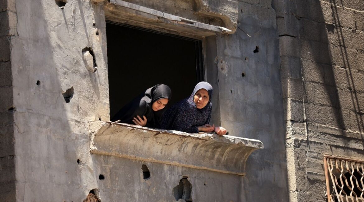 Palestinian women look from a damaged house at the site of an Israeli strike on a house that was pre-warned by the Israeli military to evacuate, before the strike was carried out late on Thursday at Shati (Beach) refugee camp, in Gaza City, May 29, 2026. (Reuters/Dawoud Abu Alkas)