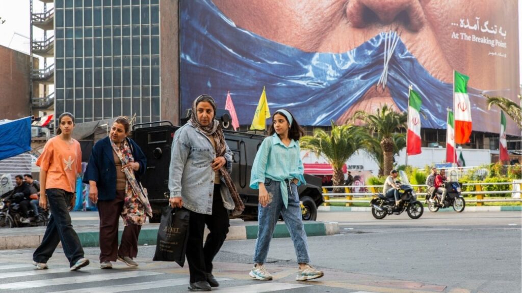People pass near a billboard showing the closure of the Strait of Hormuz over President Donald Trump’s face with a message reading “At the Breaking Point” in Tehran, May 2, 2026. President Trump on Thursday said his administration had had “very good talks” with Tehran in the last 24 hours. An Iranian official said an American plan to end the war was under review. (Arash Khamooshi/The New York Times)