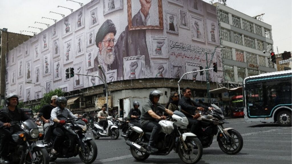 People ride motorcycles near a billboard with an image of the late Iranian Supreme Leader Ayatollah Ali Khamenei, in Tehran, Iran, May 19, 2026. Majid Asgaripour/WANA (West Asia News Agency) via Reuters