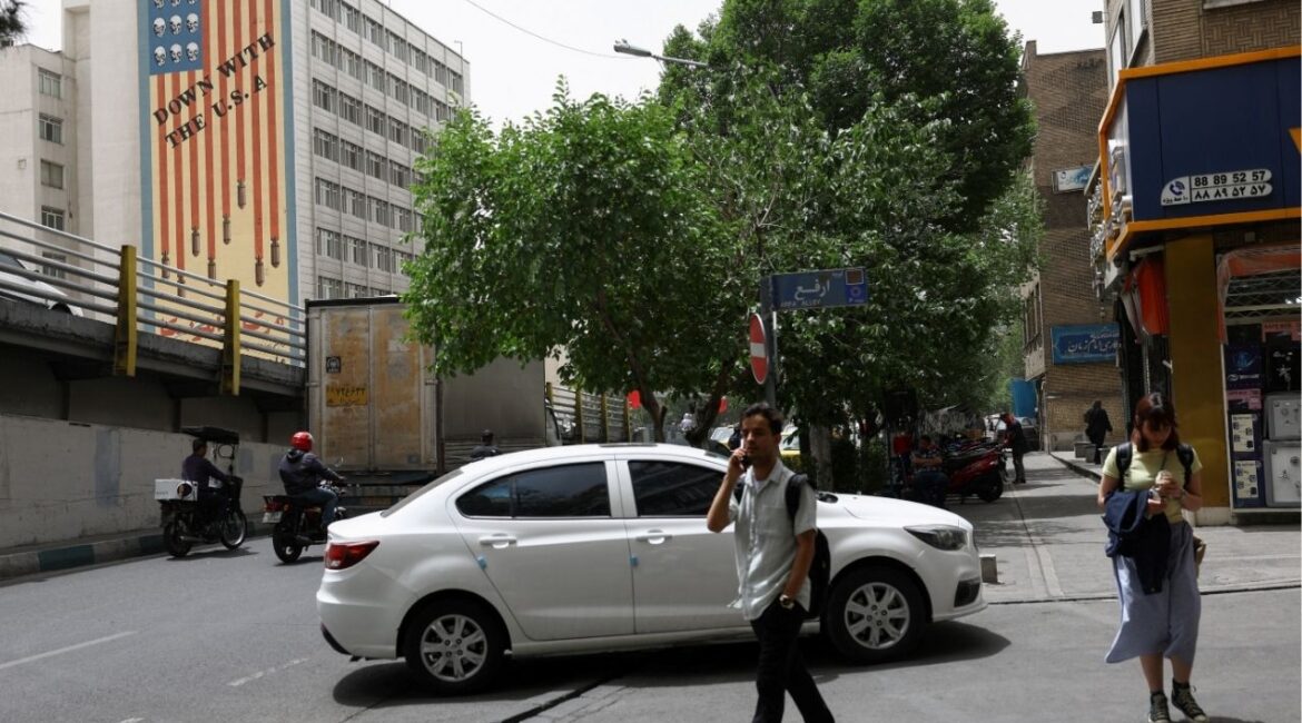 People walk near an anti-U.S. mural on a building in Tehran, Iran, May 19, 2026. Majid Asgaripour/WANA (West Asia News Agency) via REUTERS