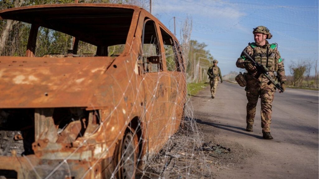 Servicemen of the consolidated Brigade 'Khyzhak' of the Ukrainian Patrol Police Department walk along a street under an anti-drone net in the town of Druzhkivka, amid Russia's attack on Ukraine, in Donetsk region, Ukraine April 28, 2026. (Reuters/Serhii Korovainyi)