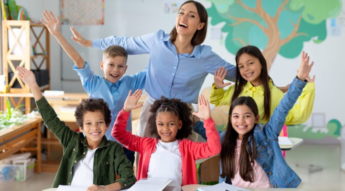 Image of a diverse happy classroom led by a female teacher
