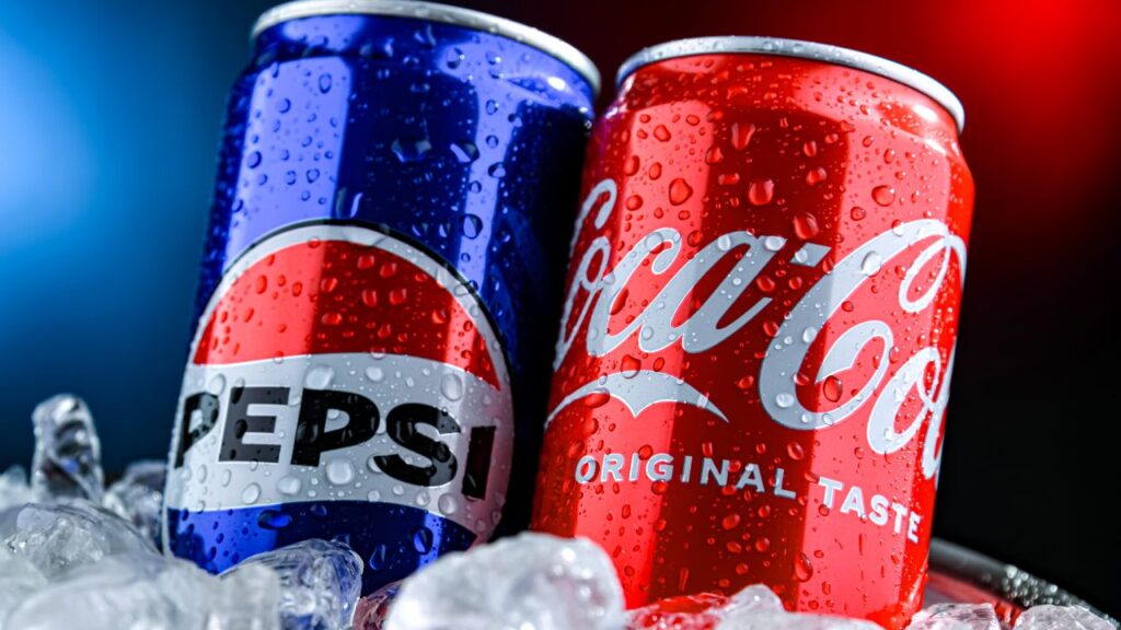 Image of a can of Pepsi and a can of Coca-Cola shoved into ice