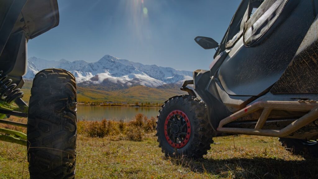 Image of souped-up off-road buggies near a lake and snow-covered mountain
