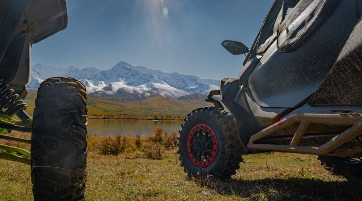 Image of souped-up off-road buggies near a lake and snow-covered mountain