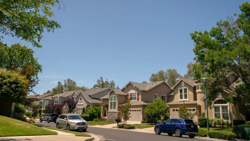 Image of an upscale neighborhood in Pleasanton, California, with two-story homes and nice landscaping featuring mature trees