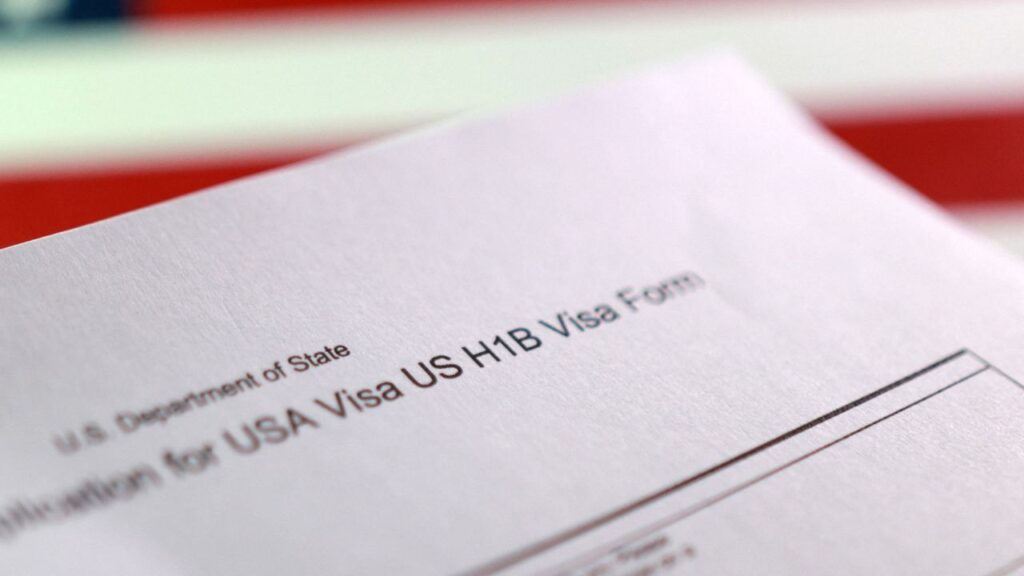 A U.S. flag and a U.S. H-1B Visa application form are seen in this illustration taken, September 22, 2025. (Reuters/Dado Ruvic/Illustration)