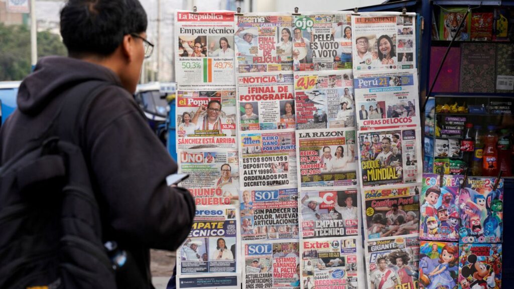 A man looks at a newspaper stand with headlines showing early results of a runoff between conservative presidential candidate Keiko Fujimori and left-wing candidate Roberto Sanchez, as Fujimori kept a slight lead over Sanchez, with over 90% of the votes counted, according to an official tally, in Lima, Peru, June 8, 2026. REUTERS/Leslie Moreno
