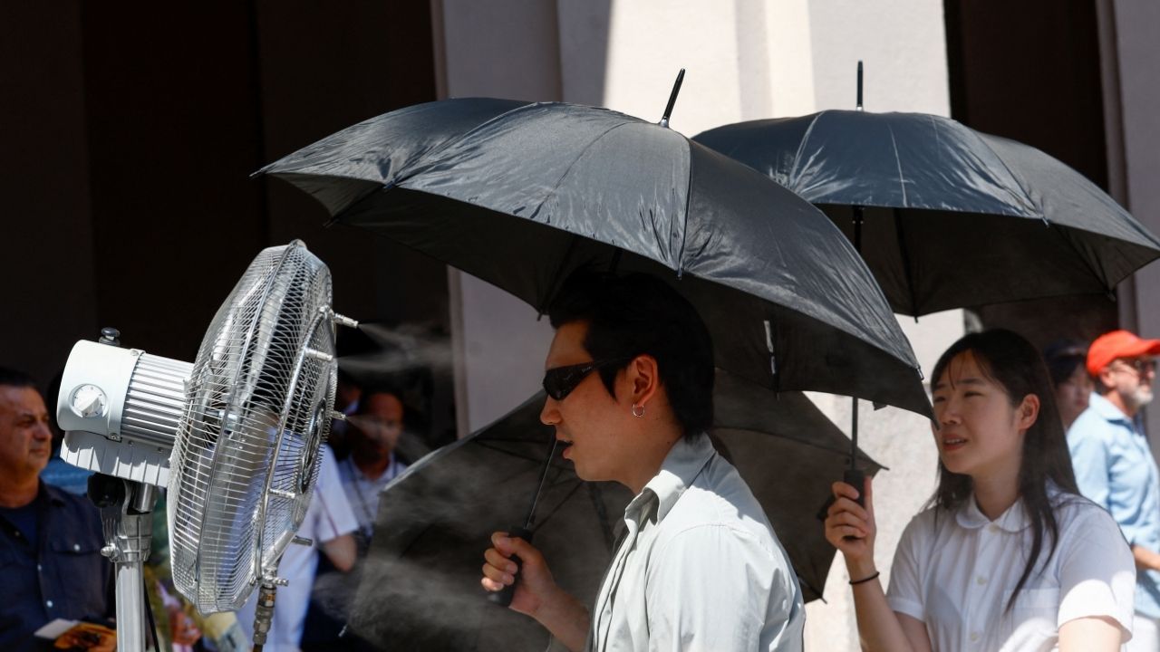 A man stands in front of a cooler spraying water ahead of Thom Browne’s Spring/Summer 2027 men’s collection show as part of Milan Fashion Week, in Milan, Italy, June 22, 2026. (Reuters/Alessandro Garofalo)